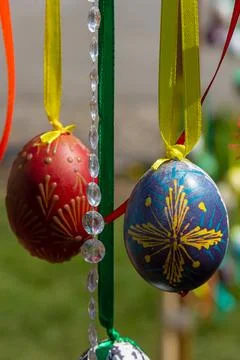 Painted eggs hang from the branches of the Easter tree. The focus is on a yel Stock Photos