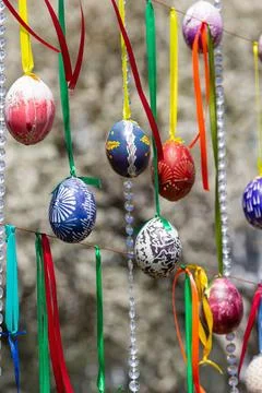 Painted eggs hang from the branches of the Easter tree. The focus is on a yel Stock Photos