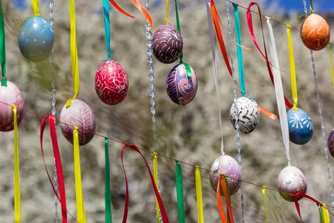 Painted eggs hang from the branches of the Easter tree. The focus is on a yel Stock Photos