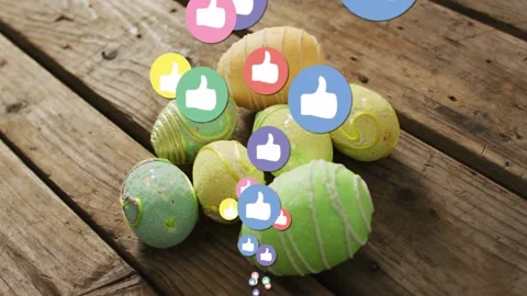 Painted eggs resting on wood plank, reaction icons appearing from bottom showing Stock Footage 332288833