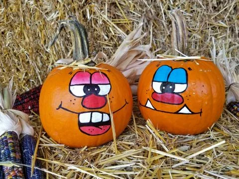 Painted faces on autumn pumpkins Stock Photos
