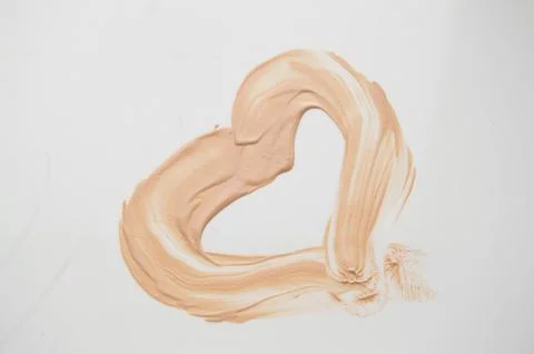 Painted heart, a smear of liquid type Foundation, concealer, white background Stock Photos