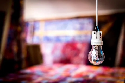 Painted light bulb hanging in a painter studio Stock Photos