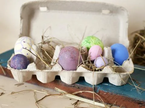 Painted multi-colored chicken and quail eggs in the package, Easter decor Stock Photos