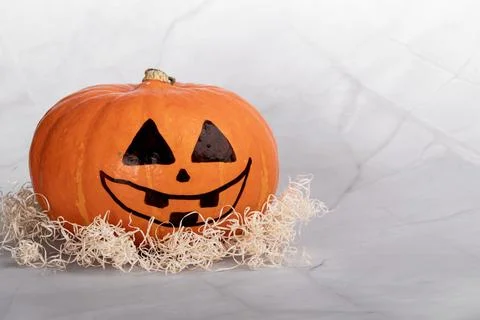 Painted orange pumpkin jack o lantern on white marble Stock Photos
