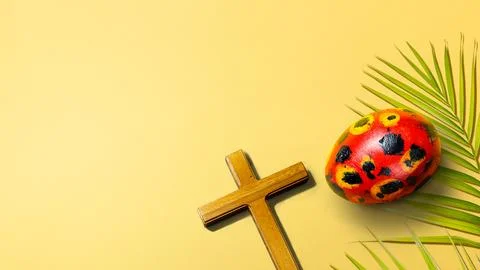 Painted red Easter egg with black and yellow patterns, a simple wooden Chri.. Stock Photos