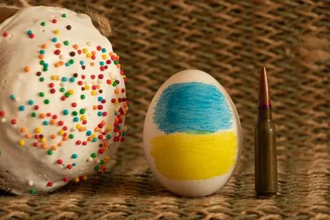 A painted Ukrainian flag on an Easter egg, and next to it Easter and a bull.. Stock Photos