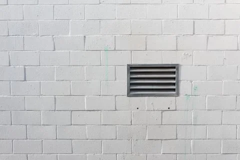 Painted white block wall with vent, green paint stains, copy space Stock Photos