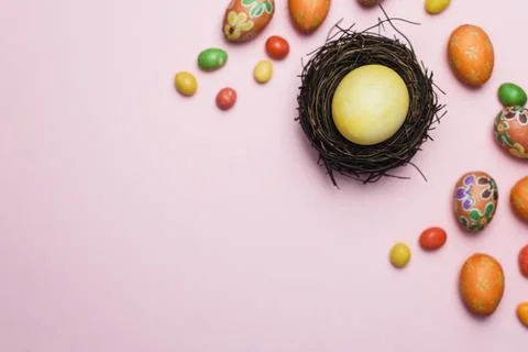 Painted yellow egg for the holiday of Easter in a nest of branches next to .. Stock Photos