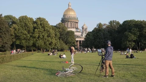 A painter in Alexander Garden, in the background St. Isaac's Cathedral Stock Footage 115480857