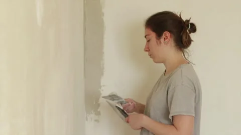 Painter aligning interior wall corner with angled trowel Stock Footage 340610687