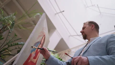 Painter applies background to portrait Stock Footage 264088950