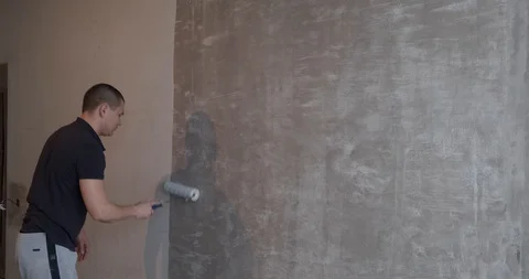 Painter applies special coating on concrete wall, roller, walls, wallpapering Stock Footage 129837620
