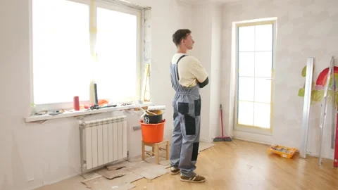 Painter contemplating next steps in empty room renovation project 動画素材 312671149