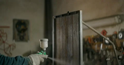 Painter covers the product with a protective layer at workshop, painting by Stock Footage 152242656