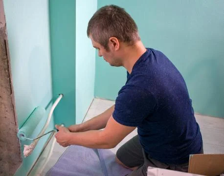 Painter covers the walls with paint. Master works as a painting roller in the 스톡 사진