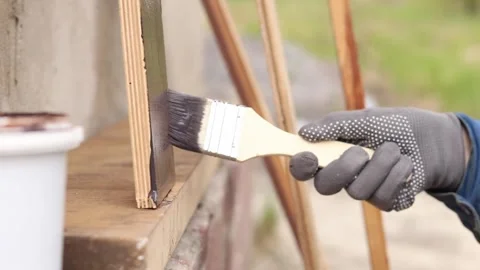 Painter covers a wooden panel with brown varnish, close-up 4 Video stock 334026827