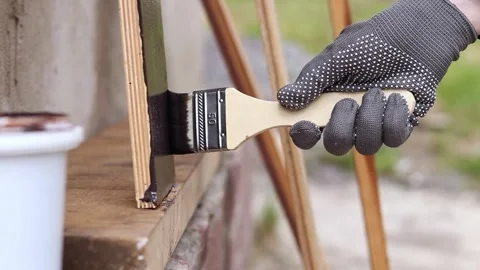 Painter covers a wooden panel with brown varnish, close-up Stock-Footage 334026863