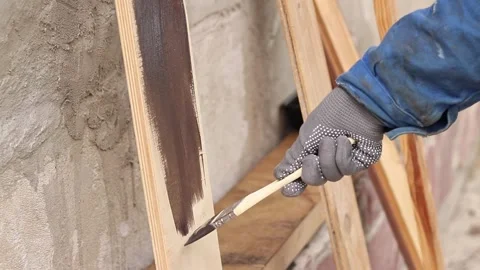 Painter covers a wooden panel with brown varnish, close-up Stock-Footage 334026871