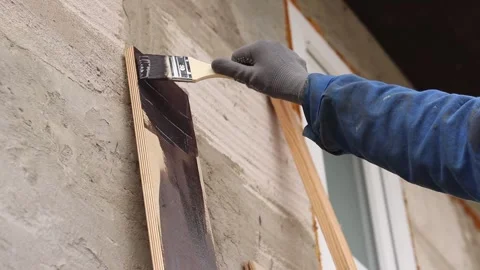 Painter covers a wooden panel with brown varnish, close-up Video stock 334026877