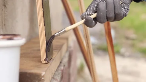 Painter covers a wooden panel with brown varnish, close-up Stock-Footage 334026897