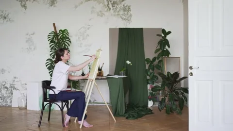 Painter. Creative work. A woman uses imagination and paints a picture in studio Stock Footage 156497428