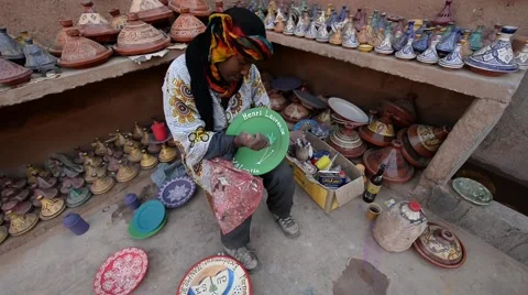 A painter decorating a plate made of clay in Maison de poterie. Stock Footage 49678642