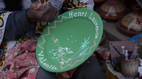 A painter decorating a plate made of clay in Maison de poterie. Stock Footage 49678760