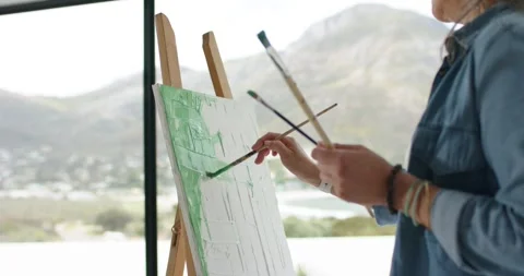 Painter is dipping brush into green paint, applying strokes to underpaint canvas 库存影片 345071243