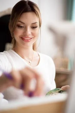 Painter drawing in art studio using easel. Portrait of a young woman painting Stock Photos
