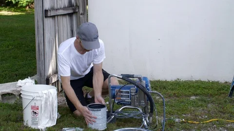 Painter Gets Paint Can Ready to Spray House Stock Footage 95483624