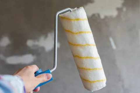 Painter hand with a paint roller Stock Photos