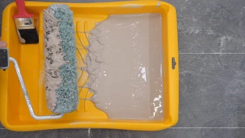 Painter hand takes roller brush and moves in yellow tray Stock Footage 124608098