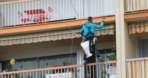 Painter Is Hanging To Paint With High Building Stock-Footage 100831384