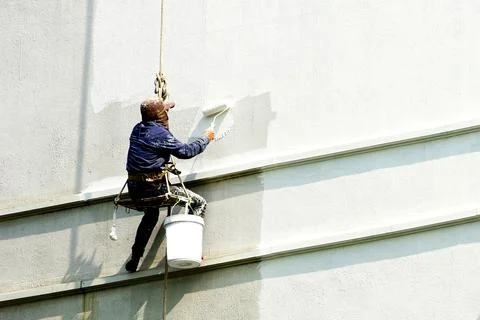 Painter hanging on white building Stock Photos