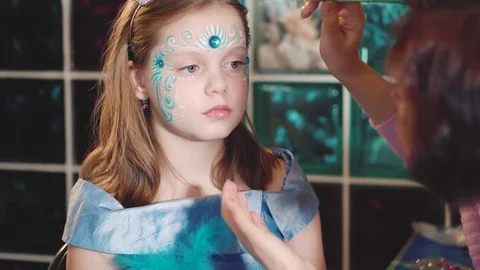 Painter makes butterfly shape at girl's face Vídeo Stock 73049928