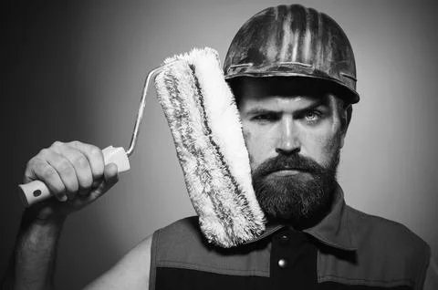 Painter man with paint roller. Professional painter in hard hat. Portrait o.. Stock Photos