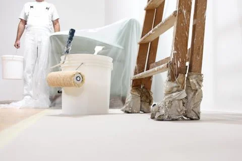 Painter man at work with a roller, bucket and scale, bottom view Photos