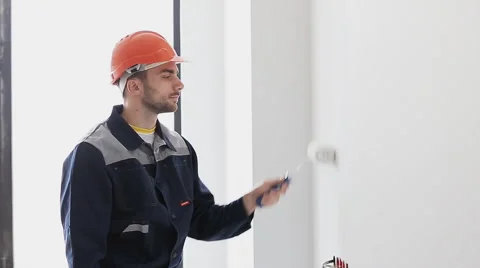 Painter man at work, with roller painting wall Stock Footage 68415687