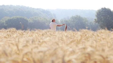 Painter in the middle of a cornfield field paints a beautiful landscape, easel Stock-Footage 28312963