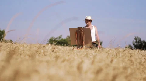 Painter in the middle of a wheat field paints a beautiful landscape, brush 스톡 동영상 28316364