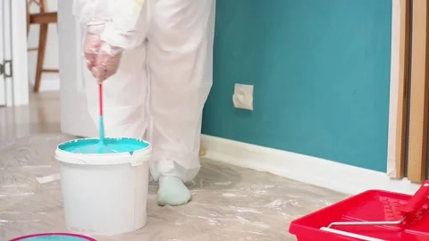 Painter mixing light blue paint in bucket Stock Footage 308018279