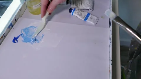 Painter mixing white and blue oil paint Stock Footage 313956954