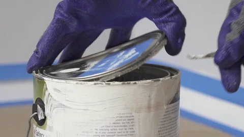Painter opening a can with white paint. Stock Footage 129139264