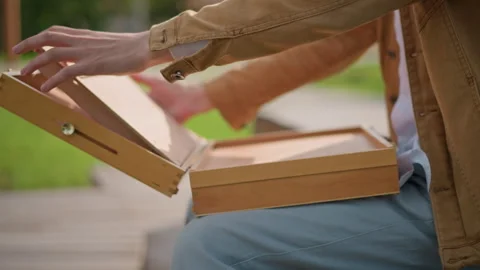Painter organizes materials in park. Sketch artist gets ready in tranquil park Stock Footage 331260313