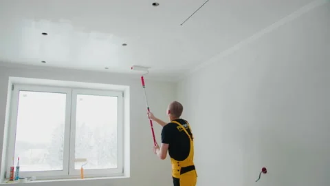 The painter painting the ceiling with white paint using a paint roller at home. Stock Footage 148166866