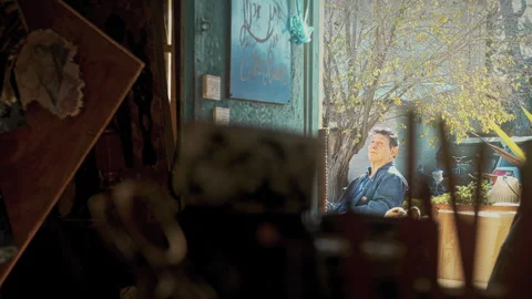 Painter painting outside his studio Stock Footage 275297875