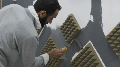 Painter painting studio wall with grey paint roll Stock Footage 220714411