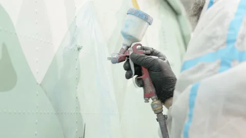 Painter paints body of helicopter with precision spray gun. professional paints Stock Footage 194904930