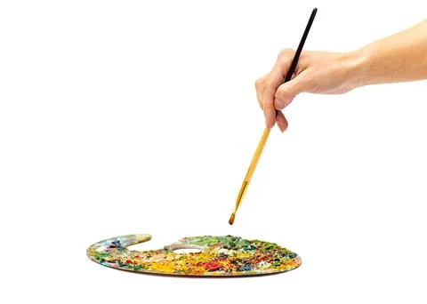 The painter paints a brush on a white background. Young woman holding brush.. Stock Photos